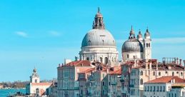 Scenic view of Venice with historic buildings, stunning domes, and boats gliding through the shimmering blue canal waters.