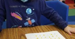 Child engaging in learning activity with alphabet worksheets and creative writing, showcasing educational development.