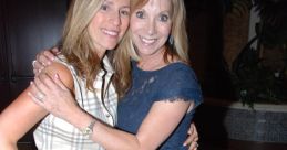 Two women smiling and embracing at a social event, showcasing friendship and joy in stylish attire.