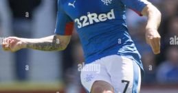 Rangers player in blue jersey kicking a soccer ball on the field, showcasing skill and athleticism during a match.