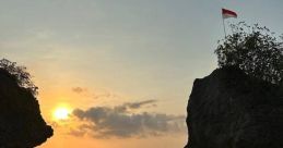 Sunset view at a serene beach with rocks and green moss, featuring a flag atop a natural formation. Ideal for nature lovers.