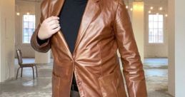 Stylish man in a brown leather blazer and black turtleneck, showcasing modern fashion in a chic indoor setting.