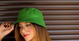 Giovanna Nieto Canto styles a green bucket hat and graphic tee, showcasing a trendy, casual look on a sunny day.