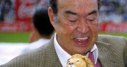 Angel Fernandez smiling while holding a lion statue, celebrating a significant achievement in sports.