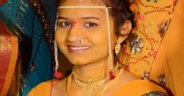 Young woman dressed in vibrant yellow saree adorned with jewelry and intricate henna designs, smiling radiantly at a festive celebration.