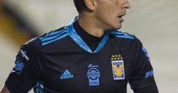 Emmanuel Moreno in goalkeeper gear holds a soccer ball, showcasing his skills on the field for Tigres UANL.