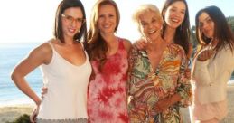 Group of five women smiling by the ocean, showcasing friendship and vibrant summer fashion styles.