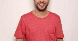 David Lucas Leal smiling warmly in a casual red shirt, showcasing a friendly and approachable demeanor.