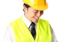 Happy worker in a safety vest and hard hat writing notes on a clipboard, symbolizing job safety and site management.