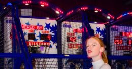 Tess B poses with a basketball at an arcade, showcasing her sporty style and confidence among vibrant game machines.