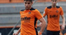 Marcos Blasco in action wearing an orange football jersey, skillfully controlling the ball during a match.