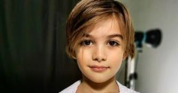 Young boy with stylish short hair wearing a white bathrobe, posing confidently in a modern studio setting.