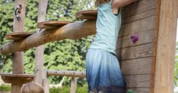 Children playing at a playground, one climbing a wooden wall while the other encourages them. Fun outdoor activity for kids.