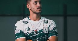 Ageu Sousa in athletic pose, showcasing team jersey with green and white design, confident expression and crossed arms.