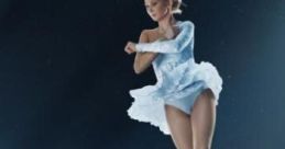 Female figure skater performing an elegant jump in a stunning light blue costume, showcasing grace and athleticism on ice.