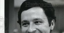 Smiling man in a suit with a paisley tie, representing a professional atmosphere, suitable for historical contexts.