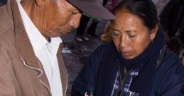 Couple handling a bird at a market, highlighting traditional practices in the Familia Amagua community.