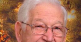 Portrait of Gilbert Nelson, a student with silver hair, wearing glasses and a black suit, smiling in front of a festive background.