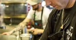 Chef Douglas Rodrigues de Castro preparing a dish in a busy kitchen, showcasing his culinary skills and tattoos.