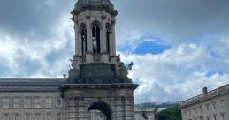 Siena Cohen posing happily in front of a historic building with a tower on a cloudy day, showcasing vibrant campus life.