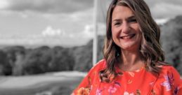 Jessica Vassallo smiling in a vibrant floral dress against a scenic outdoor backdrop, showcasing her confident style.