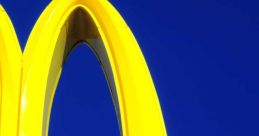 Bright yellow McDonald's arches against a blue sky, showcasing the iconic logo of this popular fast-food chain.