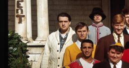 Cast of "Animal House" in iconic poses outside the fraternity house, showcasing classic collegiate styles and humor.