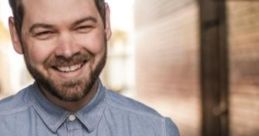 Smiling man in a denim shirt, showcasing a warm personality and vibrant background, perfect for Nicholas Fargher’s profile.