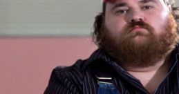 Character from "Letterkenny" displaying a serious expression, wearing overalls and a red cap, embodying rural Canadian humor.