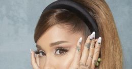 Ariana Grande showcasing her iconic style with a green ensemble, elegant hair, and striking tattoos.