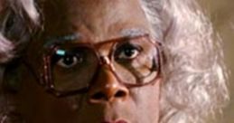 Madea character with silver hair and glasses, wearing an orange outfit, showcasing a dramatic and expressive look.