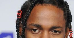 Kendrick Lamar with intricate braids and a statement necklace, showcasing his distinct style at a public event.