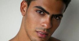 Attractive young Mexican man with chiseled features, showcasing a confident gaze and a toned physique against a neutral background.