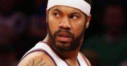 Rasheed Wallace in New York Knicks jersey, showcasing his striking tattoo and intense game focus on the court.