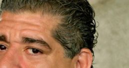 Close-up of Joey Diaz with curly hair, wearing a black suit and white shirt, showcasing his expressive features.