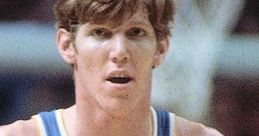 Bill Walton in a UCLA jersey, showcasing his iconic number 32 during an intense basketball game moment.