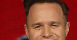 Olly Murs smiles broadly in a stylish suit, showcasing his charm and personality at a media event.