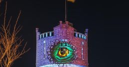 Colorful light projections on Helder water tower at night, featuring an eye and intricate designs, capturing vibrant art.