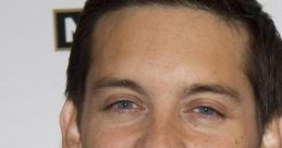 Tobey Maguire smiles at a public event, showcasing his stylish black suit and charming demeanor.