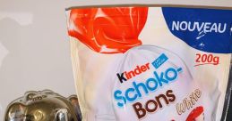 White Kinder Schoko-Bons pack next to a Buddha statue and a decorative elephant, showcasing delicious chocolate treats.