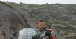 Rider on a BMW motorcycle navigating rocky terrain with snow, ready for adventure and exploration in the wilderness.