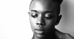 Elegant portrait of a woman with a shaved hairstyle, showcasing beauty and expression in black and white tones.