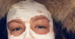 Young woman with a facial mask, wearing a furry hood, showcasing a skincare routine for healthy skin in the UK.