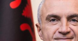 Ilir Meta, Albanian politician, poses confidently against a backdrop of the Albanian flag, showcasing national pride and leadership.