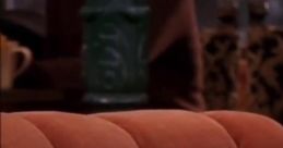 Close-up of a cozy orange couch from the iconic sitcom "Friends," setting the scene for Joey's humorous antics.