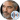 Close-up portrait of George Clooney, showcasing his distinguished gray beard and stylish suit against a dark background.