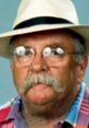 Wilford Brimley, known for diabetes advocacy, sports a distinctive mustache and hat, reflecting his iconic style.