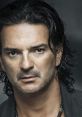 Ricardo Arjona's intense gaze and signature style highlight his captivating presence in Latin music.