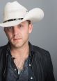 Justin Moore in a stylish black leather jacket and white cowboy hat, showcasing his signature country artist look.