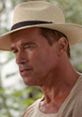 Arnold Schwarzenegger in a straw hat showcasing his intense character in "Collateral Damage," a thrilling action film.